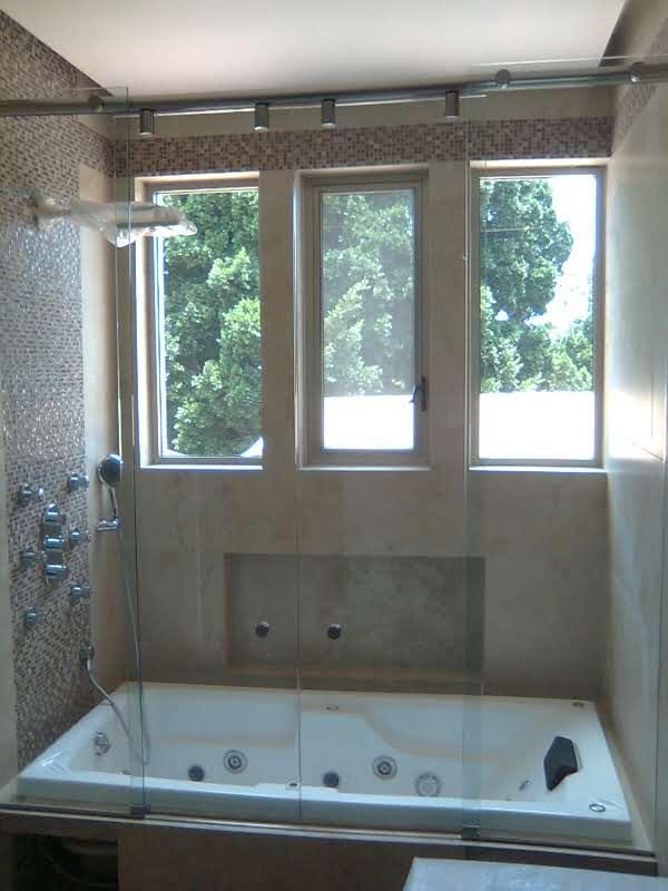 División de cristal junto a tina de baño